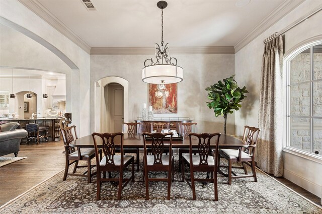 dining space featuring baseboards, arched walkways, and dark wood finished floors