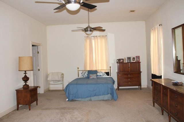 bedroom featuring baseboards, a ceiling fan, visible vents, and light colored carpet