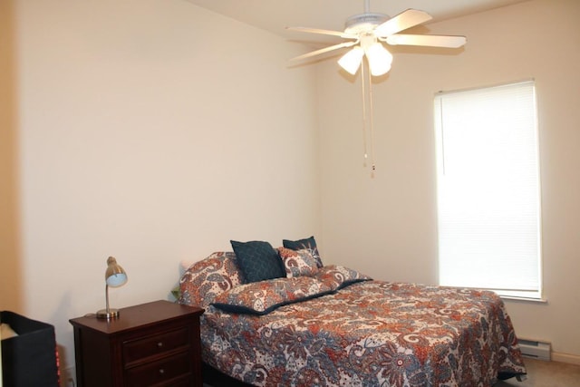 carpeted bedroom with ceiling fan and a baseboard radiator