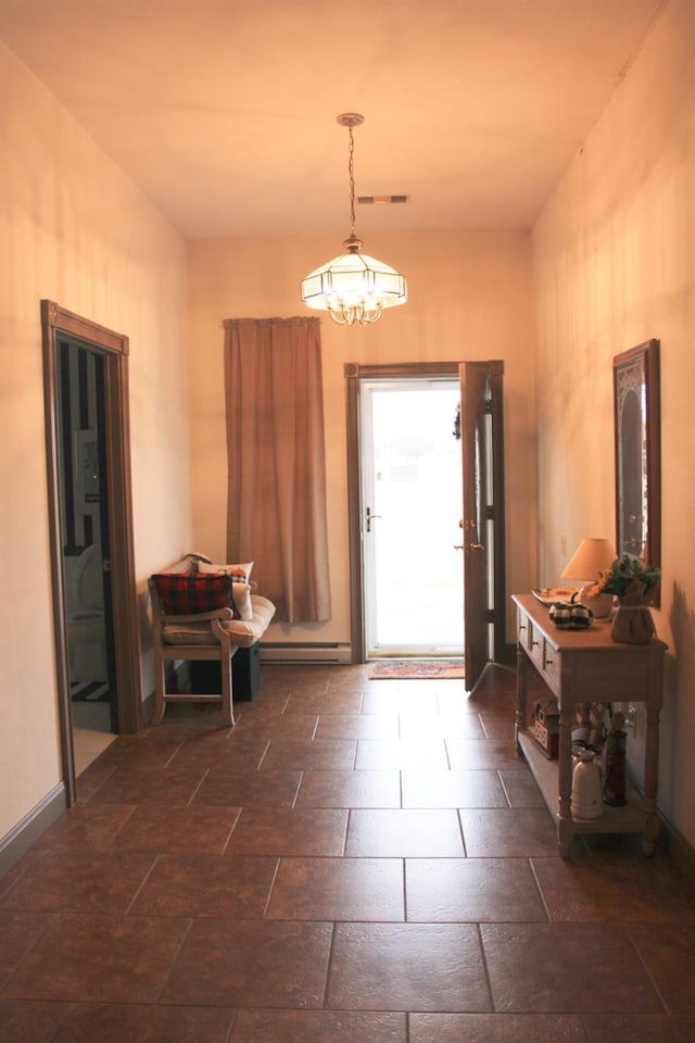 entrance foyer with a baseboard heating unit, stone tile flooring, and baseboards