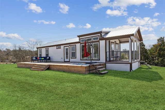 back of property featuring metal roof and a lawn