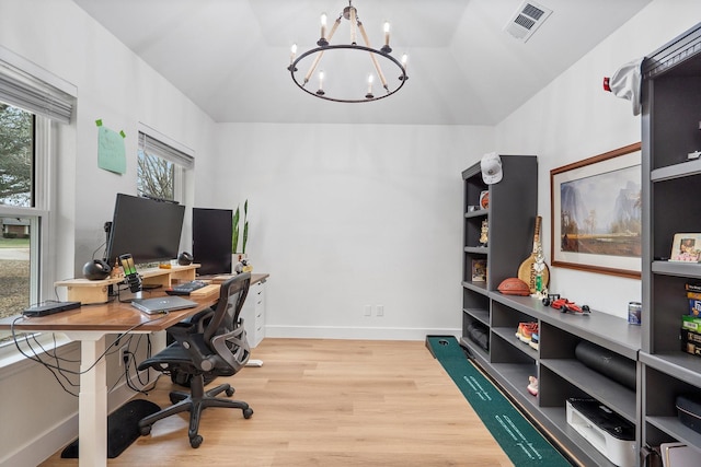 home office with a notable chandelier, visible vents, light wood-style flooring, vaulted ceiling, and baseboards