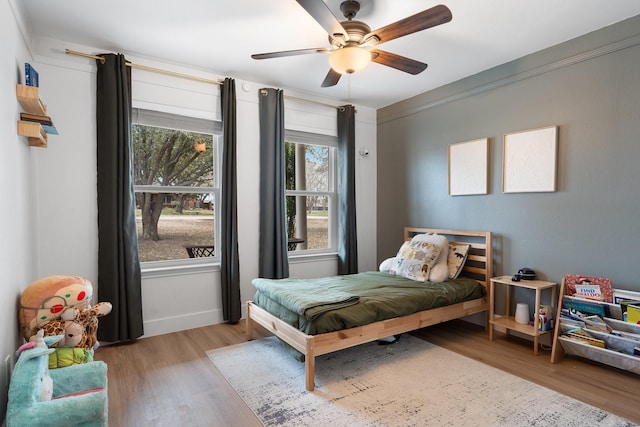 bedroom with ceiling fan, light wood-style flooring, and baseboards