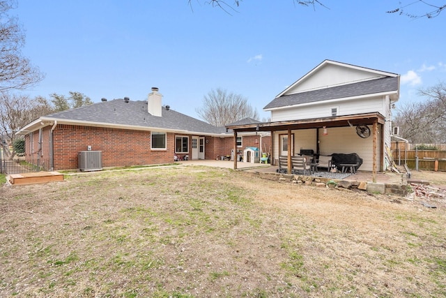 back of property featuring a chimney, fence, cooling unit, a patio area, and brick siding