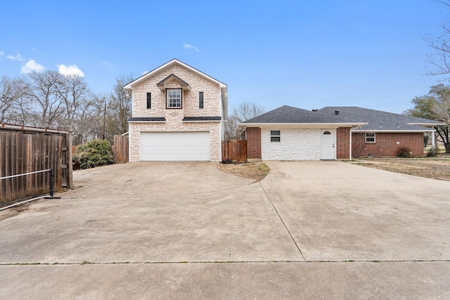 traditional-style home featuring stone siding, roof with shingles, fence, and concrete driveway