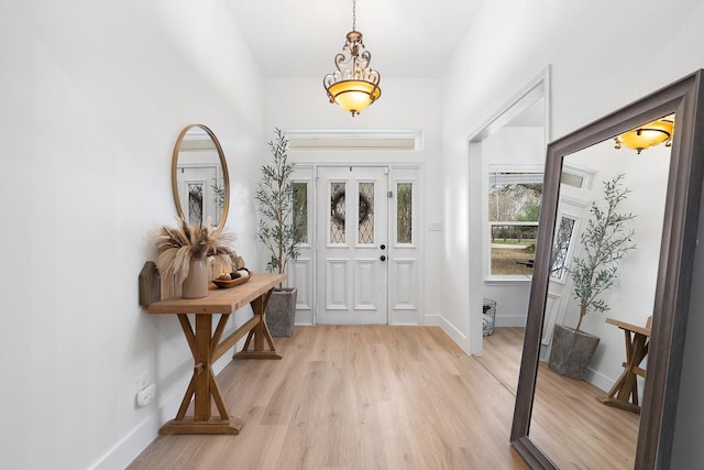 foyer featuring light wood-style flooring and baseboards