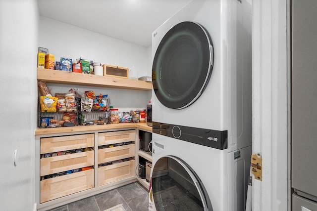 clothes washing area with stacked washer / dryer and laundry area