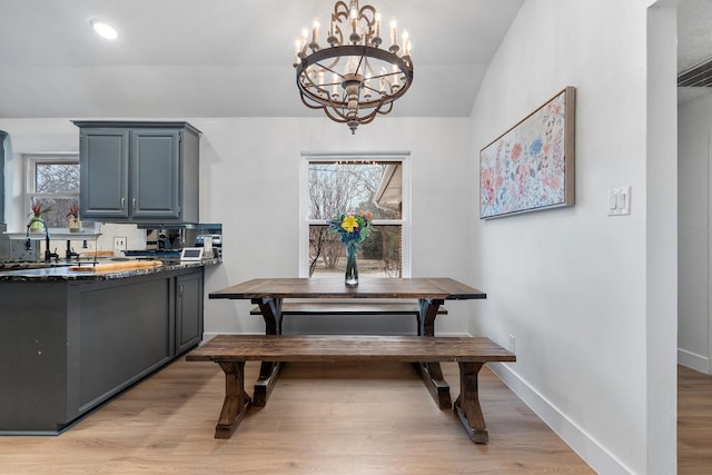 dining space with recessed lighting, light wood-style flooring, baseboards, and an inviting chandelier