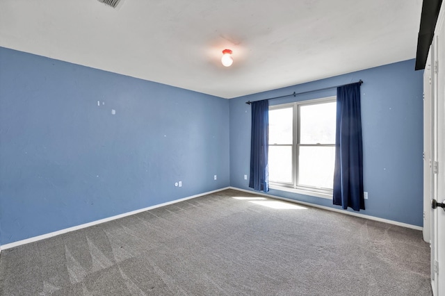 empty room featuring carpet flooring and baseboards