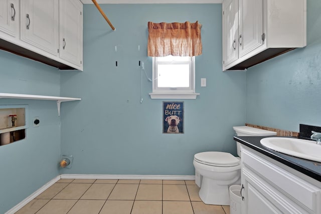 bathroom featuring toilet, tile patterned flooring, vanity, and baseboards