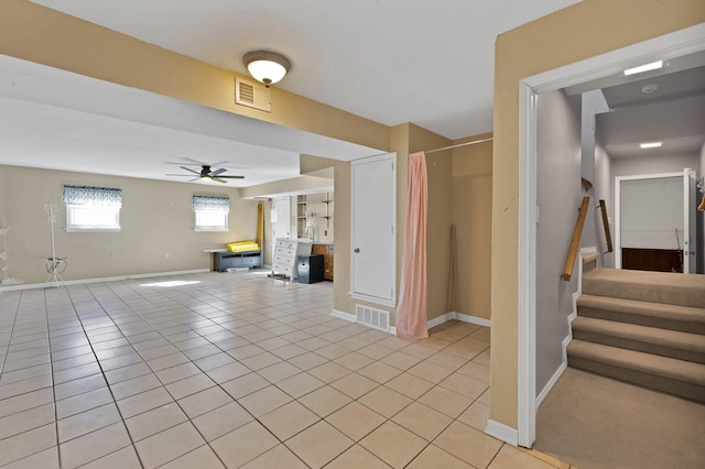 unfurnished living room with light tile patterned floors, ceiling fan, stairway, and visible vents