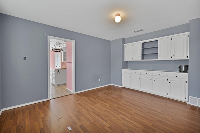 kitchen with visible vents, open shelves, light countertops, and white cabinetry