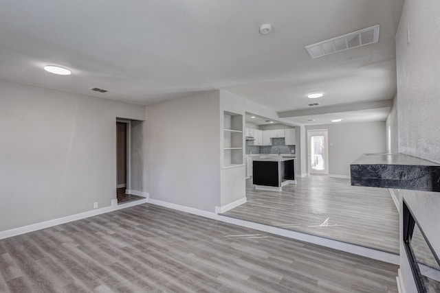 138 Whippoorwill Dr, Dallas, TX 75224 - unfurnished living room featuring light wood-style flooring, baseboards, and recessed lighting