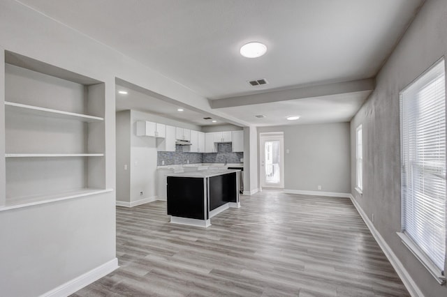 138 Whippoorwill Dr, Dallas, TX 75224 - kitchen featuring white cabinetry, under cabinet range hood, open floor plan, a kitchen island, and light countertops