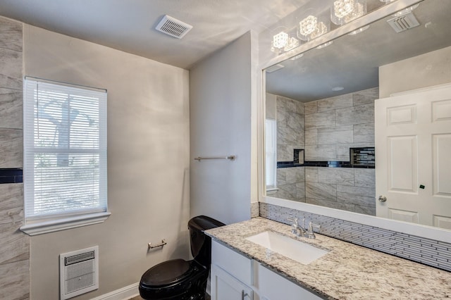 138 Whippoorwill Dr, Dallas, TX 75224 - bathroom with vanity, heating unit, toilet, a tile fireplace, and baseboards