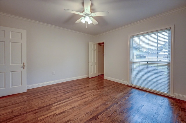 empty room with baseboards, dark wood-type flooring, and crown molding