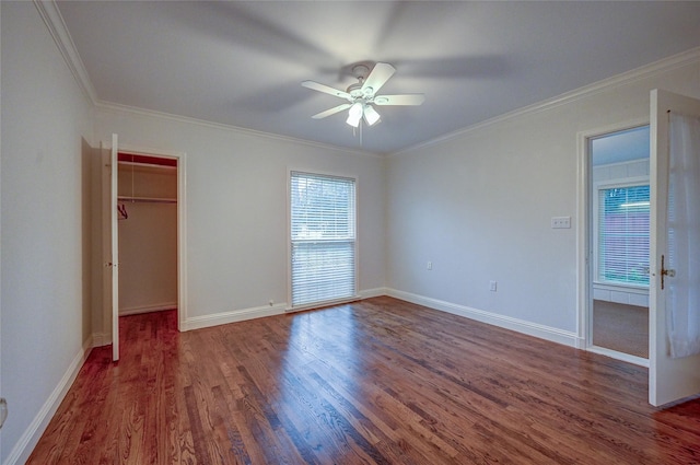 unfurnished bedroom with baseboards, ornamental molding, and dark wood finished floors