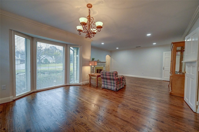 living area with a fireplace, ornamental molding, and dark wood-style flooring