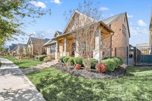 view of front facade with brick siding, a front lawn, fence, and a residential view