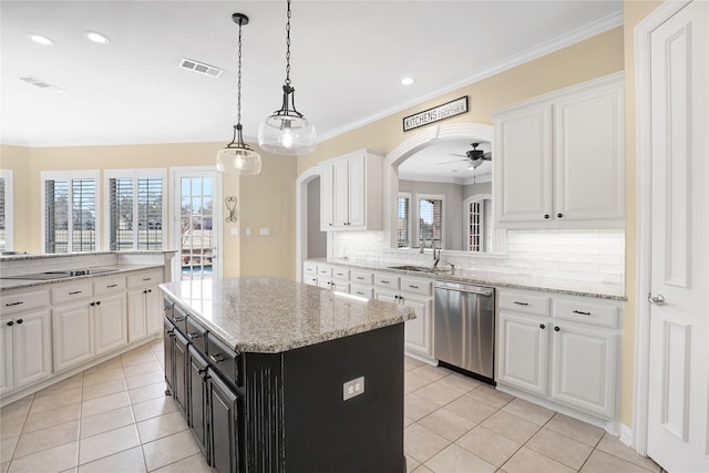 kitchen with visible vents, arched walkways, dishwasher, white cabinetry, and a sink