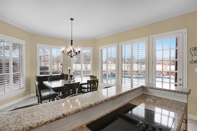 dining area with baseboards, ornamental molding, and an inviting chandelier