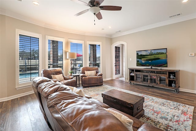 living area featuring baseboards, visible vents, wood finished floors, and ornamental molding