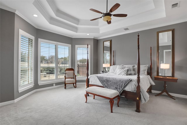 bedroom featuring carpet flooring, visible vents, baseboards, ornamental molding, and a tray ceiling