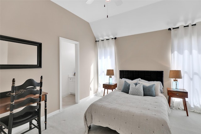 bedroom featuring connected bathroom, light carpet, a ceiling fan, baseboards, and vaulted ceiling