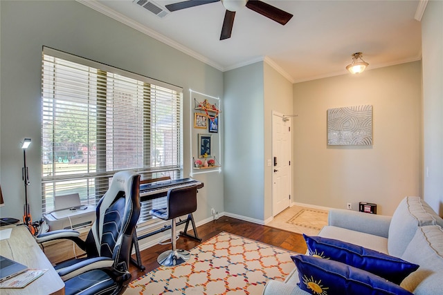 office space featuring wood finished floors, a ceiling fan, visible vents, baseboards, and ornamental molding