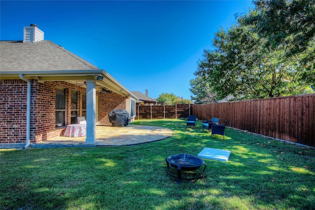 view of yard featuring a patio area, an outdoor fire pit, and a fenced backyard