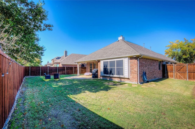 rear view of property featuring a patio, a fenced backyard, brick siding, a lawn, and a gate