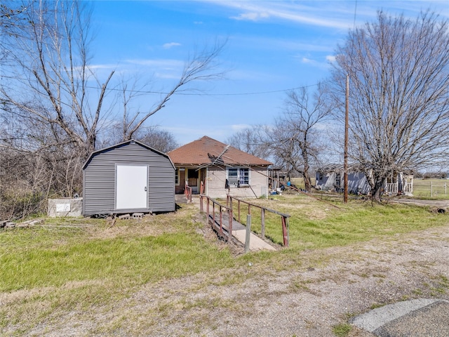 view of front facade featuring an outdoor structure, a front lawn, and a shed