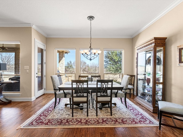 dining room featuring crown molding, a notable chandelier, a textured ceiling, wood finished floors, and baseboards