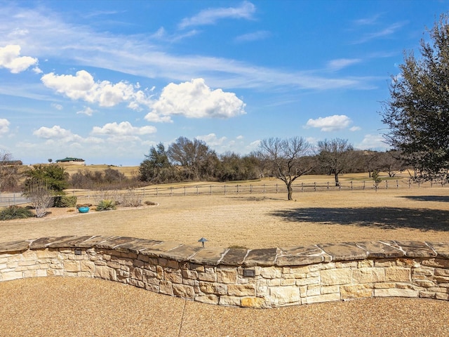 view of yard featuring a rural view and fence