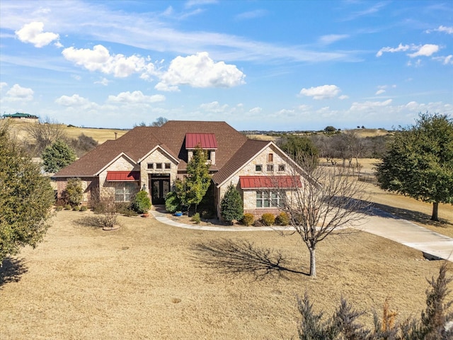 view of front of home with a standing seam roof, stone siding, and metal roof