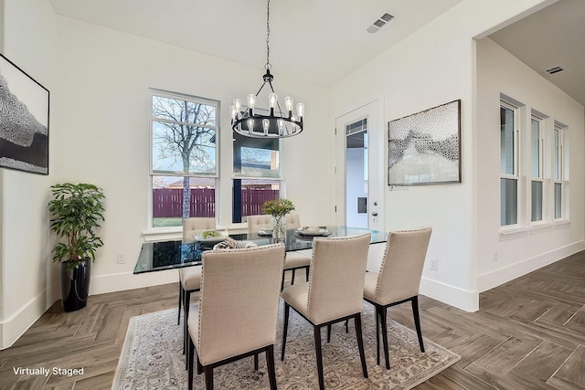 dining space with baseboards, visible vents, and an inviting chandelier