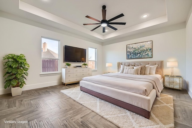 bedroom featuring ceiling fan, recessed lighting, a raised ceiling, and baseboards