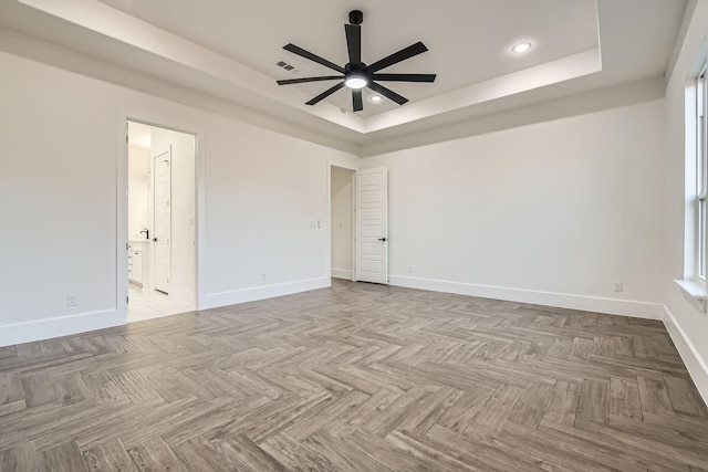 spare room with baseboards, visible vents, a raised ceiling, and recessed lighting