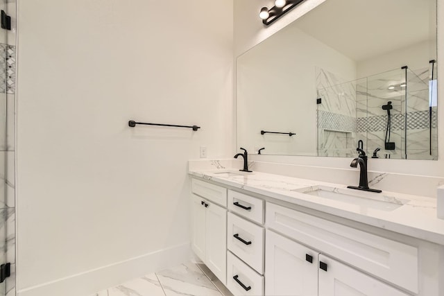 full bathroom featuring marble finish floor, a sink, baseboards, and double vanity