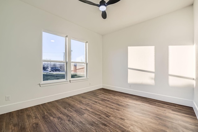 empty room with dark wood-style floors, ceiling fan, and baseboards