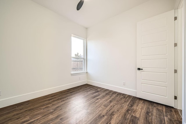 unfurnished room featuring ceiling fan, baseboards, and dark wood finished floors