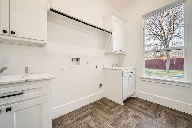 clothes washing area featuring hookup for a washing machine, cabinet space, electric dryer hookup, and baseboards