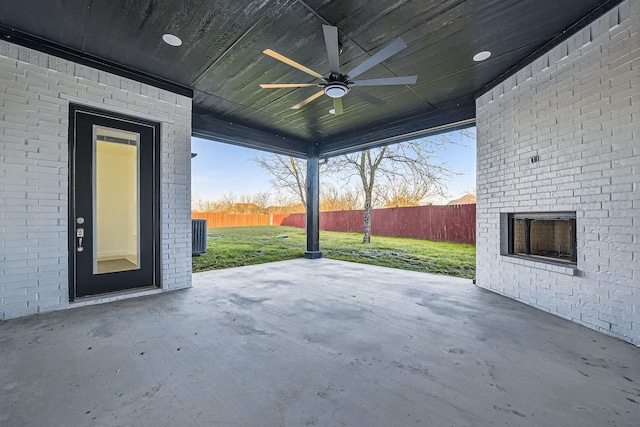 view of patio / terrace with a fenced backyard, a ceiling fan, and an outdoor brick fireplace