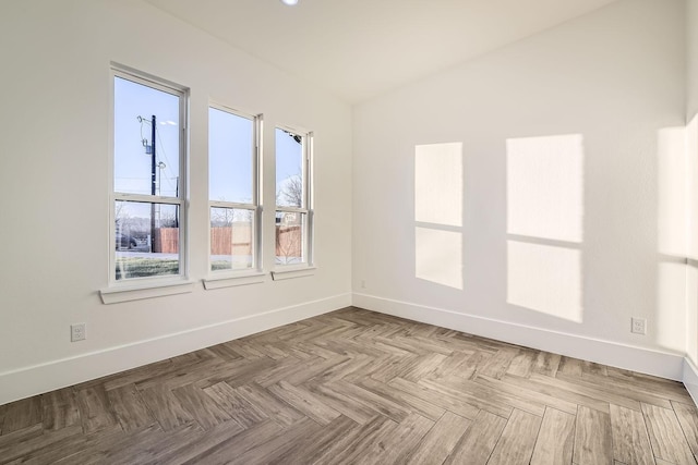 spare room with vaulted ceiling and baseboards