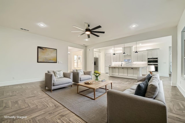 living room with visible vents, baseboards, a ceiling fan, and recessed lighting