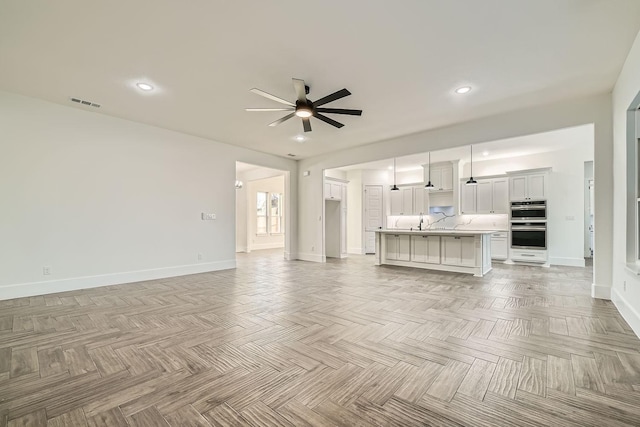 unfurnished living room featuring a ceiling fan, recessed lighting, and baseboards