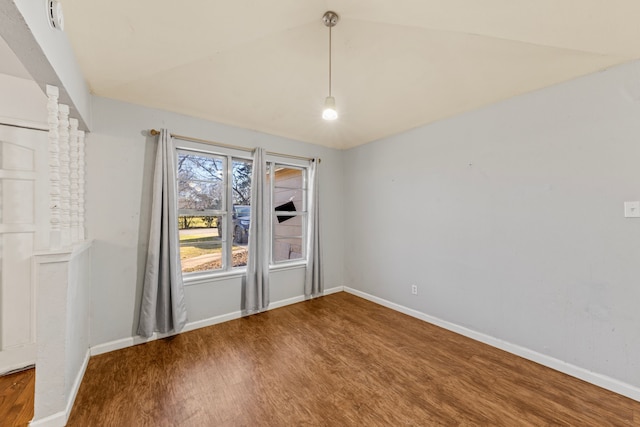 spare room with lofted ceiling, ornate columns, wood finished floors, and baseboards