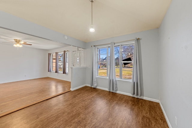 unfurnished room with ceiling fan, wood finished floors, and baseboards