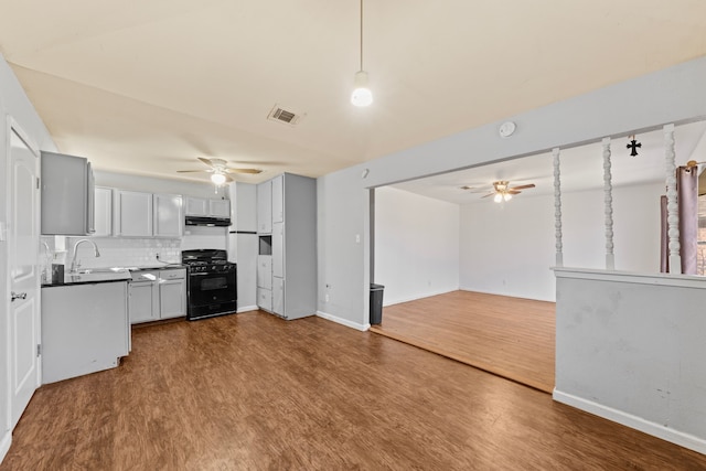 kitchen with under cabinet range hood, a ceiling fan, visible vents, open floor plan, and gas stove