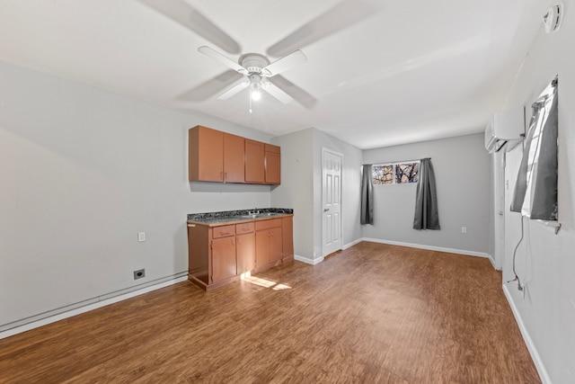 interior space featuring dark countertops, light wood-type flooring, baseboards, and brown cabinetry